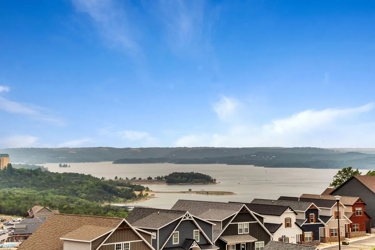 A sweeping view over Table Rock Lake, with an island and surrounding hills visible. The tranquil scene suggests opportunities for sunset views, morning coffee on the deck, and peaceful relaxation—elements that enhance the lakeside atmosphere.